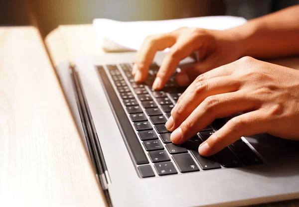 Close-up of the keyboard and hands of an investor using a laptop and reporting the results of business planning, finance, investment, division, and risk assessment in the work organization.