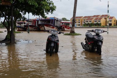 Hoi An, Vietnam, 17 Ekim 2021, Hoi An, Vietnam 'da Thu Bon nehrinin yanındaki sel basmış bir caddeye iki motosiklet park etti.