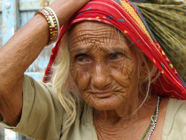 Mandawa, Rajasthan, Hindistan, 11 Ağustos 2011: Mandawa, Rajasthan, Hindistan 'da bir evin kapısında çuval taşıyan yaşlı bir kadının portresi