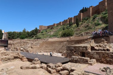 Malaga, İspanya, 8 Mayıs 2022: Arkasında Alcazaba 'nın savunma duvarı bulunan Roma tiyatrosu, İspanya