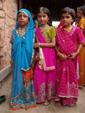 Rajasthan, Hindistan, 15 Ağustos 2011: Hindistan 'ın bağımsızlık gününü kutlamak için renkli kıyafetler giymiş üç okul kızının dikey görünümü
