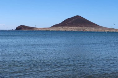 El Medano, Tenerife, İspanya, 8 Mart 2022: El Medano, Tenerife, İspanya 'da volkanik kumdan oluşan Kızıl Dağ plajı