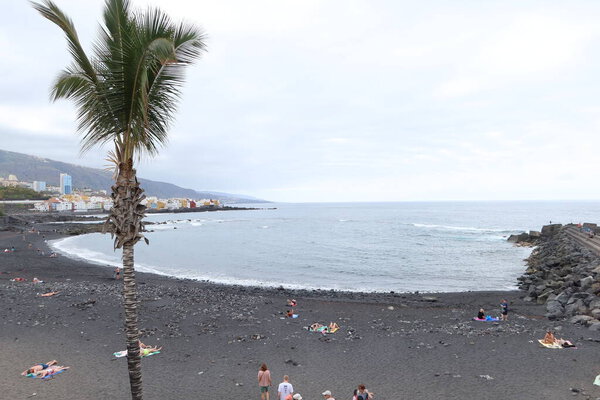 Jardin beach, Puerto de la Cruz, Tenerife, Spain, May 27, 2022: The quiet Jardin beach with volcanic black sand and beautiful gardens on the Atlantic ocean, Puerto de la Cruz, Tenerife, Spain