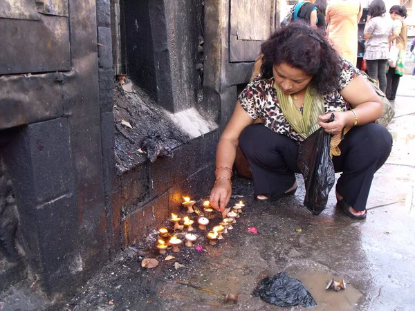 2011年8月20日 尼泊尔加德满都 一名妇女在斯瓦扬布斯古寺点燃蜡烛 尼泊尔加德满都 — 图库照片