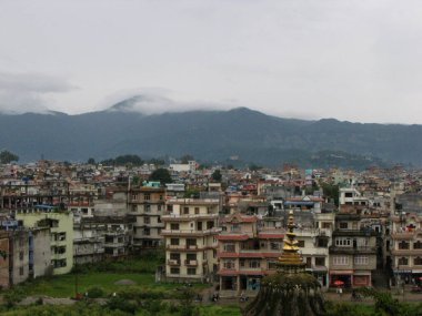 Kathmandu, Nepal, August 19, 2011: Buildings along the Bagmati River with the Himalayas in the background in Kathmandu, Nepal