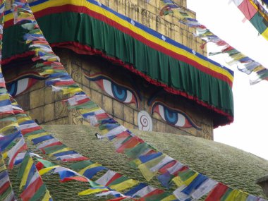 Kathmandu, Nepal, August 20, 2011: Buddha eyes at Boudhanath Stupa decorated with bunting in Kathmandu, Nepal
