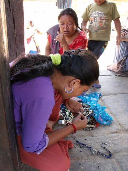 Durbar Square, Patan, Kathmandu, Nepal, August 20, 2011: Vertical view of a woman making handicrafts in Durbar Square, Patan, Kathmandu, Nepal