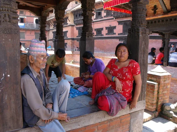 Durbar Square, Patan, Kathmandu, Nepal, August 20, 2011: Several people sitting in the shade in Durbar Square, Patan, Kathmandu, Nepal