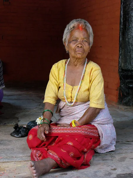 Durbar Square, Patan, Kathmandu, Nepal, August 20, 2011: A woman sitting on a street in Durbar Square, Patan, Kathmandu, Nepal