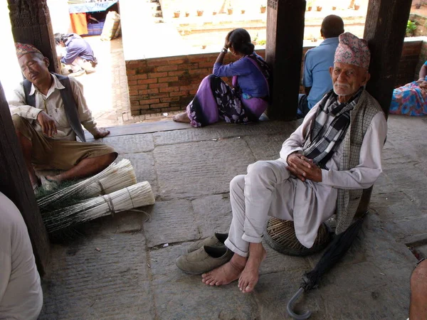 Durbar Square, Patan, Kathmandu, Nepal, August 20, 2011: Several men sitting in the shade in Durbar Square, Patan, Kathmandu, Nepal