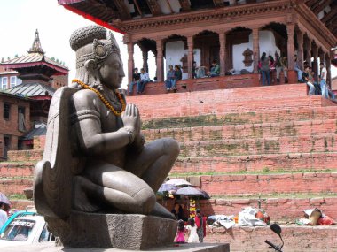 Kathmandu, Nepal, August 20, 2011: Sculpture of a deity next to a wooden building in a square in Kathmandu. Nepal