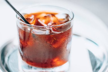 Buzlu soğuk bira ve beyaz arka planda siyah pipet. Kahve ile nefis soğuk içecek..