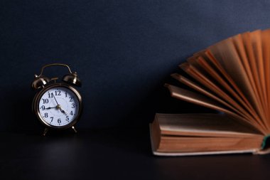 Masaüstünde kitap ve alarm saati