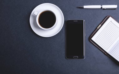 Kahve akıllı telefon ve defterler.