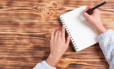 Kız bir defterde yazar