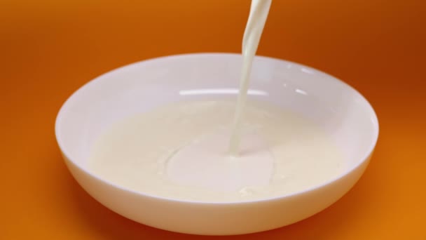 Pouring milk into the plate — Stockvideo