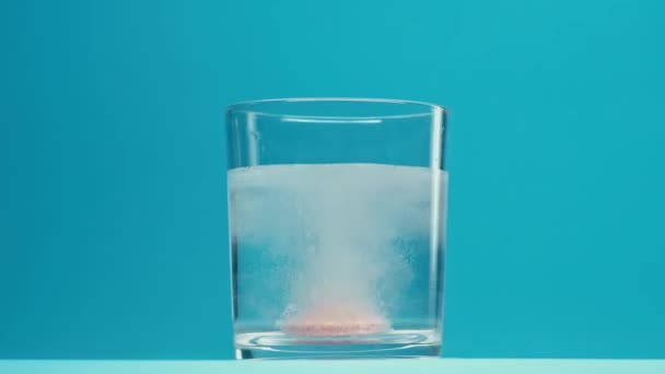 Sparkling Pill Drops Glass Water Blue Background — Vídeos de Stock