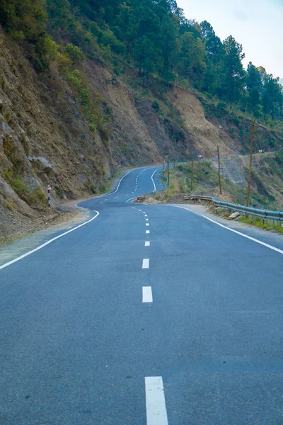 Uzun tepeli rüzgarlı yollar, bir tarafında dağlar, diğer tarafında hendek.