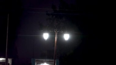 Gece karanlığında yanan sokak fenerleri karanlık sokaklara ışık saçıyor.