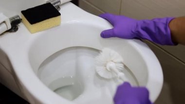 4K görüntü, temizlikçi temizlik fırçası kullanarak kirli tuvaleti temizliyor..