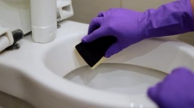 Adam tuvaleti fırçayla temizliyor. Tuvaletteki kirli tuvaleti temizlemek için.