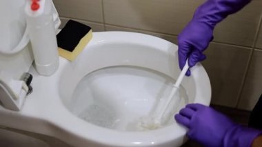 Adam tuvaleti fırçayla temizliyor. Tuvaletteki kirli tuvaleti temizlemek için.