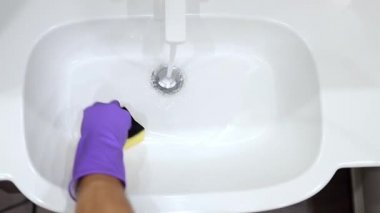 Eldivenli yaşlı adamı süngerle banyoyu temizlerken çek. ilk kişi görünümü