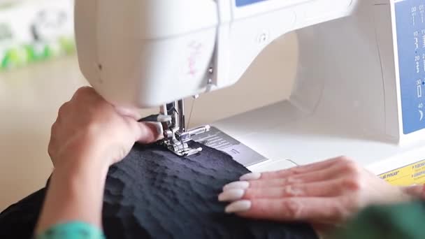 在这个视频中 我们看到了在缝纫车间工作的过程的一个特写 妇女的手握住织物 用打字机织成线条 小企业的时尚概念 — 图库视频影像