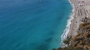 Yüksek bir yerden kumsalın manzarası. Deniz sörfü ve boş deniz plajı.