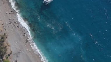 Fetihye 'de parlak ve güneşli bir günde Oludeniz' den Kelebek Vadisi 'ne ve Kabak Vadisi' ne giden turizm korsan gemisinin insansız hava aracının muhteşem manzarası.