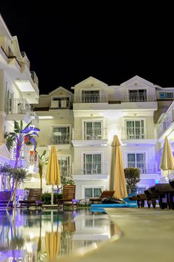 Alacakaranlıkta bir tatil köyü yüzme havuzu, lüks tasarım iyi ışık ve temiz peyzaj ile.