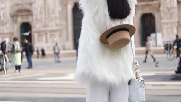 ミラノのドゥオーモの前で女性モデルの肖像画 女の子の白い毛皮のコートと茶色の帽子 — ストック動画