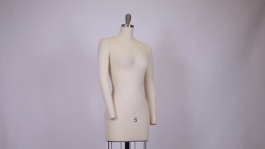 Kumaş ve metalik eski model elbise mankeni temiz ve temiz arka planda tek başına duruyor..