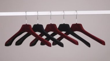 Duvarda gri bir arka planda izole edilmiş birçok askı var. Mağaza konsepti, satış, tasarım, boş askı. Metin için yer.