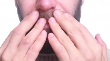 Beyaz bir adam sakalına dokunuyor. Beyaz bir adam tıraşsız yüzünü okşar. Tıraşsız erkek yüzü yakın plan..