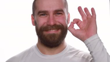 Olumlu genç adam kameraya gülümsüyor. Hippi adam beyaz arka planda 