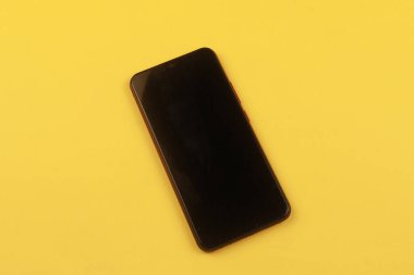 Sarı arka planda fotokopi alanı olan akıllı bir telefon. Tasarım, Güzel Sanatlar, Minimalizm