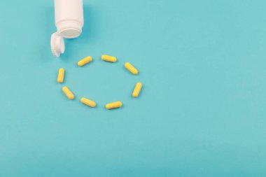 Mavi arka planda sarı haplar, kapatın. Metin için kopyalama alanı olan mavi arkaplan. Sağlıklı ve ilaç.