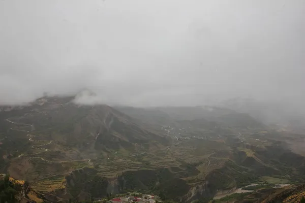 Rusya 'nın Ural Dağı' nın tepesindeki haşin dağ manzarası. Kayalar sis bulutlarıyla kaplı.