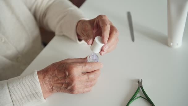 Стара Жінка Зморщеними Руками Відкриває Скляну Пляшку Спеціального Прозорого Лаку — стокове відео