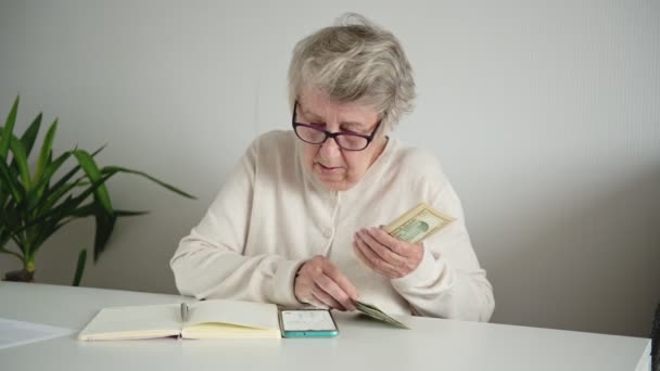 Жінка рахує пенсійний розподіл доходів за допомогою телефону — стокове відео
