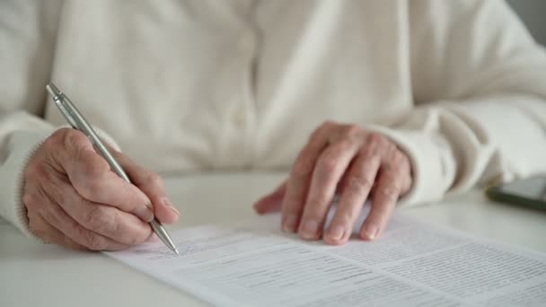 Yaşlı kadın kontrat makrosu sayfalarına imza bırakıyor — Stok video
