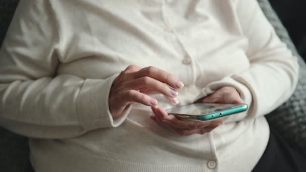 Vieille femme avec des mains ridées types message sur téléphone mobile — Video