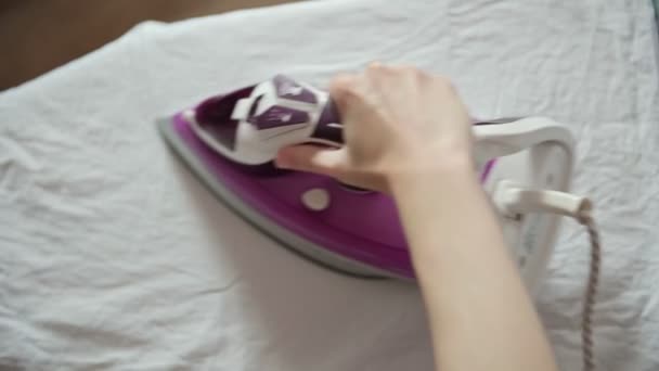 妇女在熨烫板上的白布板上使用热熨斗 — 图库视频影像