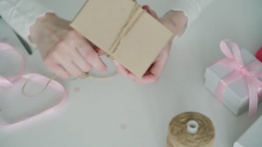 İnce gömlek ve karton kutu giyen kadın tasarımcı elleri masa yüzeyine bağlı ince kablo kullanarak mevcut.