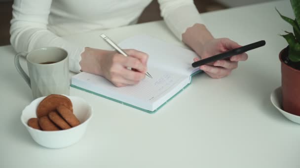 Žena Bílém Tričku Plánuje Posílání Textovek Přáteli Telefonu Psaní Poznámek — Stock video