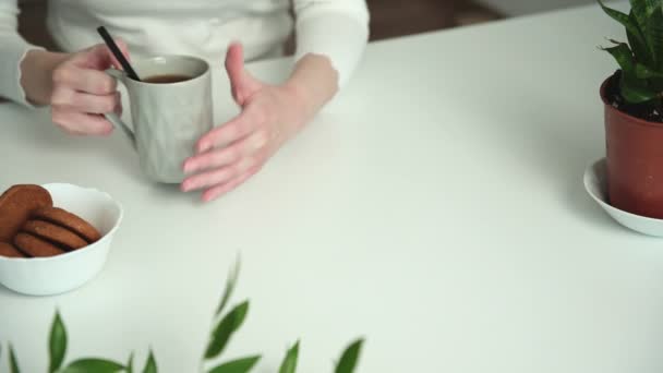 Nce Tişörtlü Kadın Otla Süslenmiş Beyaz Masasına Oturur Fincandan Tatlı — Stok video