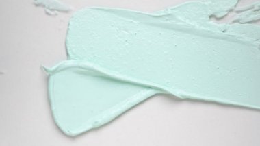 Metal spatula ile beyaz yüzey üzerinde el yapımı yeşil bir kil maske. Güzellik için doğal kozmetik ürünü