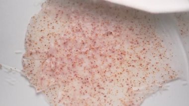 Beyaz masa üzerine metal spatula ile doğal pembe vücut fırçası serpiştiriyorum. Güzellik için ev yapımı cilt bakımı ürünü