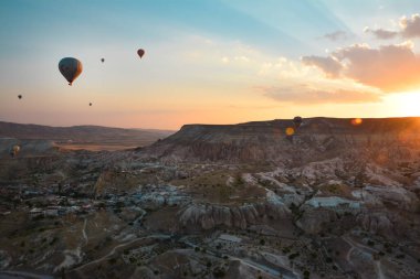Kapadokya 'nın tuhaf dağları arasında gün doğumunda yükselen inanılmaz balonlar.